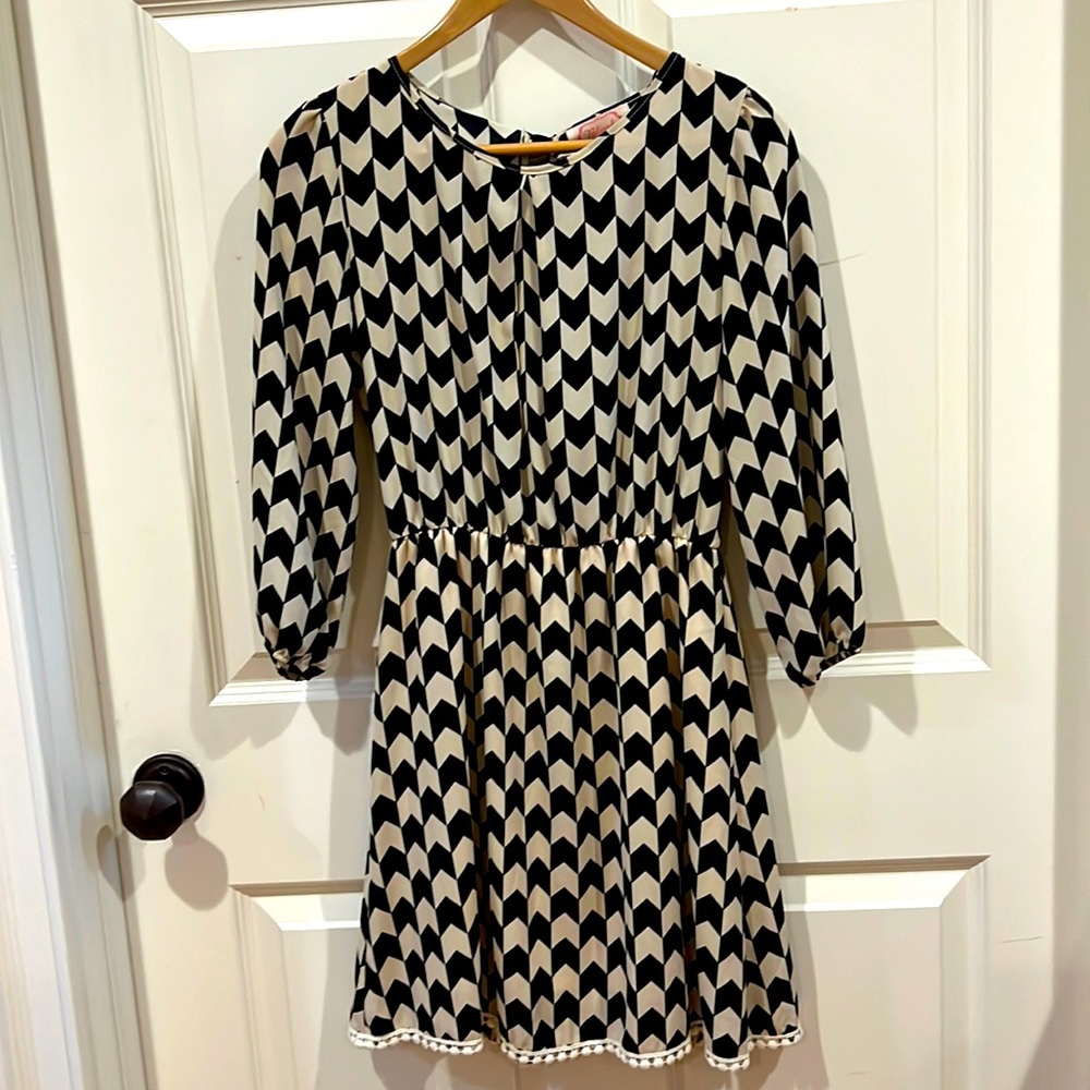 Blush jewel neck checkered mini dress with open back detail tied with a bow.